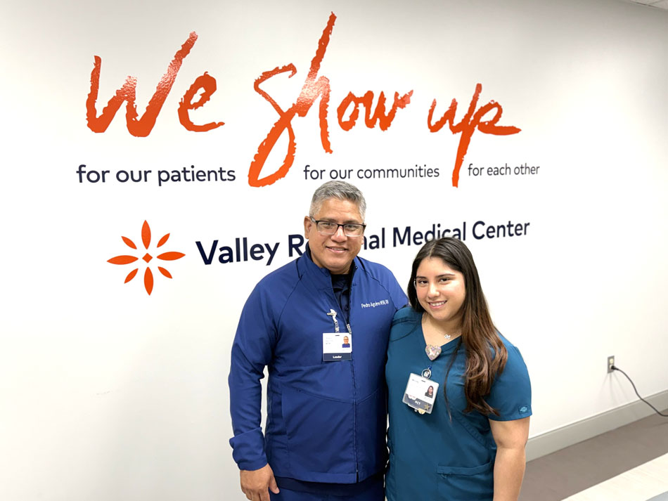 Aguiree Family: pete and melody aguirre in front of we show up sign.