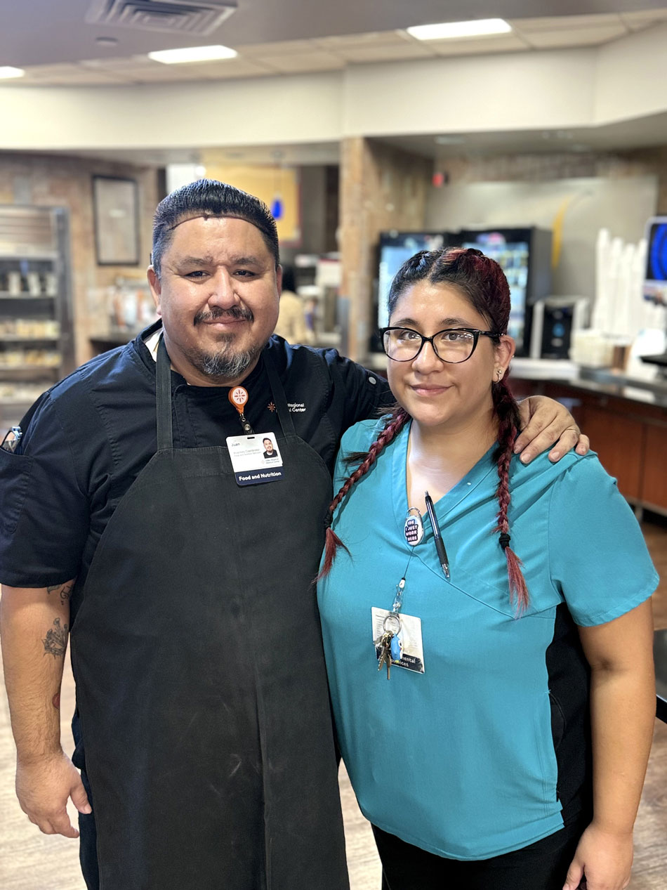 Garza's at work: Juan and Mariela Garza with arms around each other in hospital cafeteria.