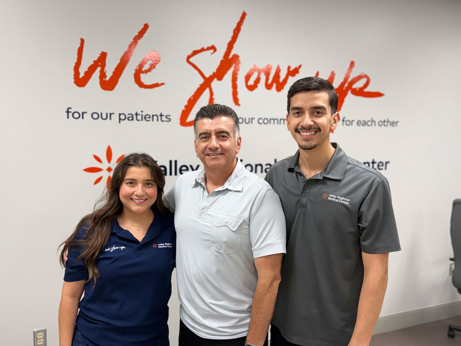 Leos family: Karina, Ramon and Mario standing in front of we show up sign.