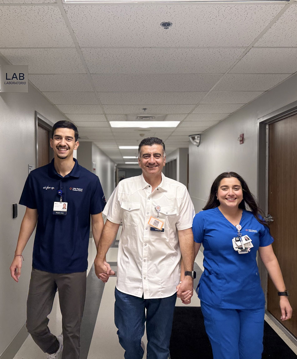 leos at work: Mario, Ramon and Karina walking in hospital hallway near laboratory.